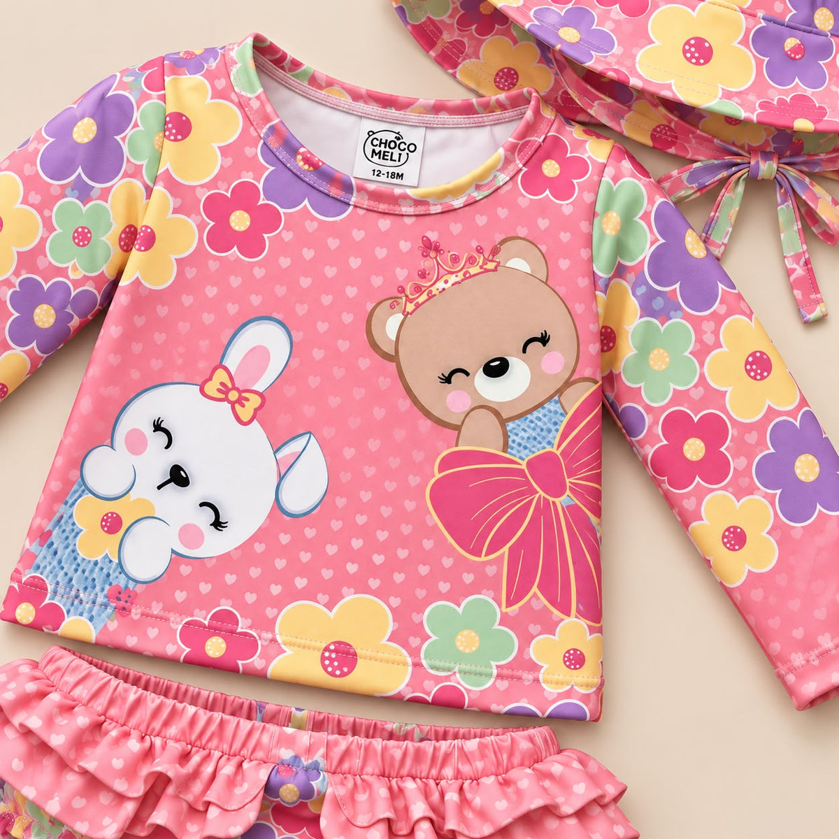 Bebé niña con vestido de baño rosado de flores y gorro de ala ancha a juego
