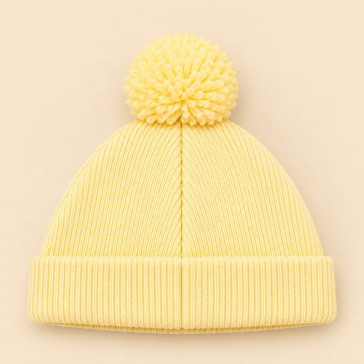 Gorro tejido para bebé amarillo pastel con pompón