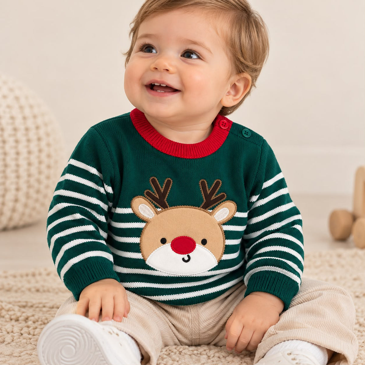 Bebé usando suéter navideño tejido verde con aplique de reno