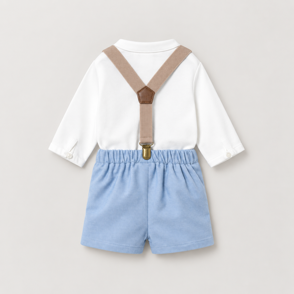 Detalle de camisa blanca con botones y tirantes beige sobre pantalón corto azul claro Mayoral