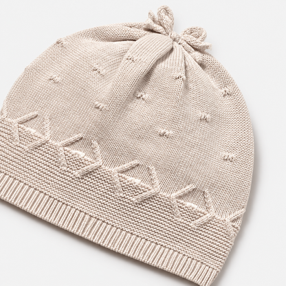 Gorro tricot beige con lazo y cenefa decorativa para recién nacida