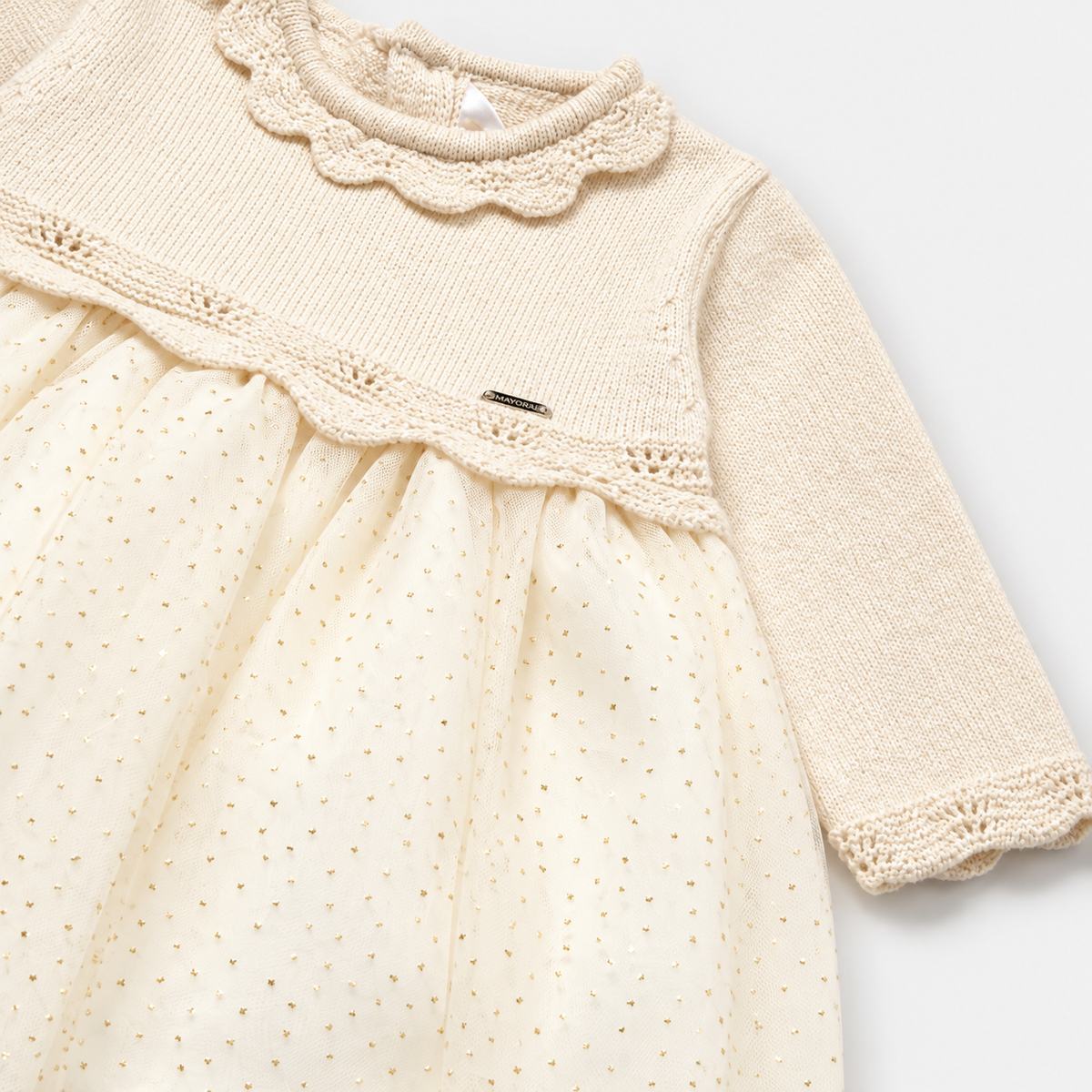 Detalle de cuello calado y falda de tul con puntos del vestido Mayoral para recién nacida