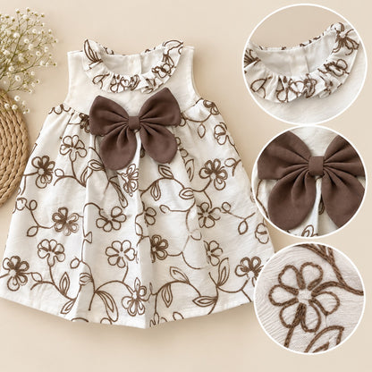Detalle del cuello con volante, moño café y flores bordadas del vestido infantil