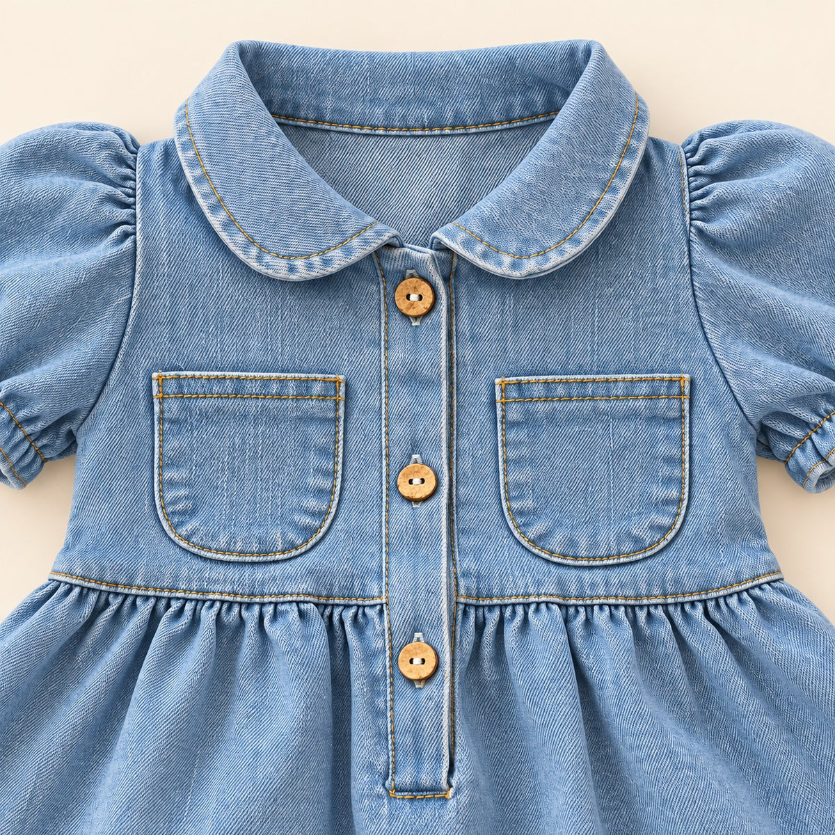 Detalle de manga abullonada con terminación elástica en vestido azul claro para bebé