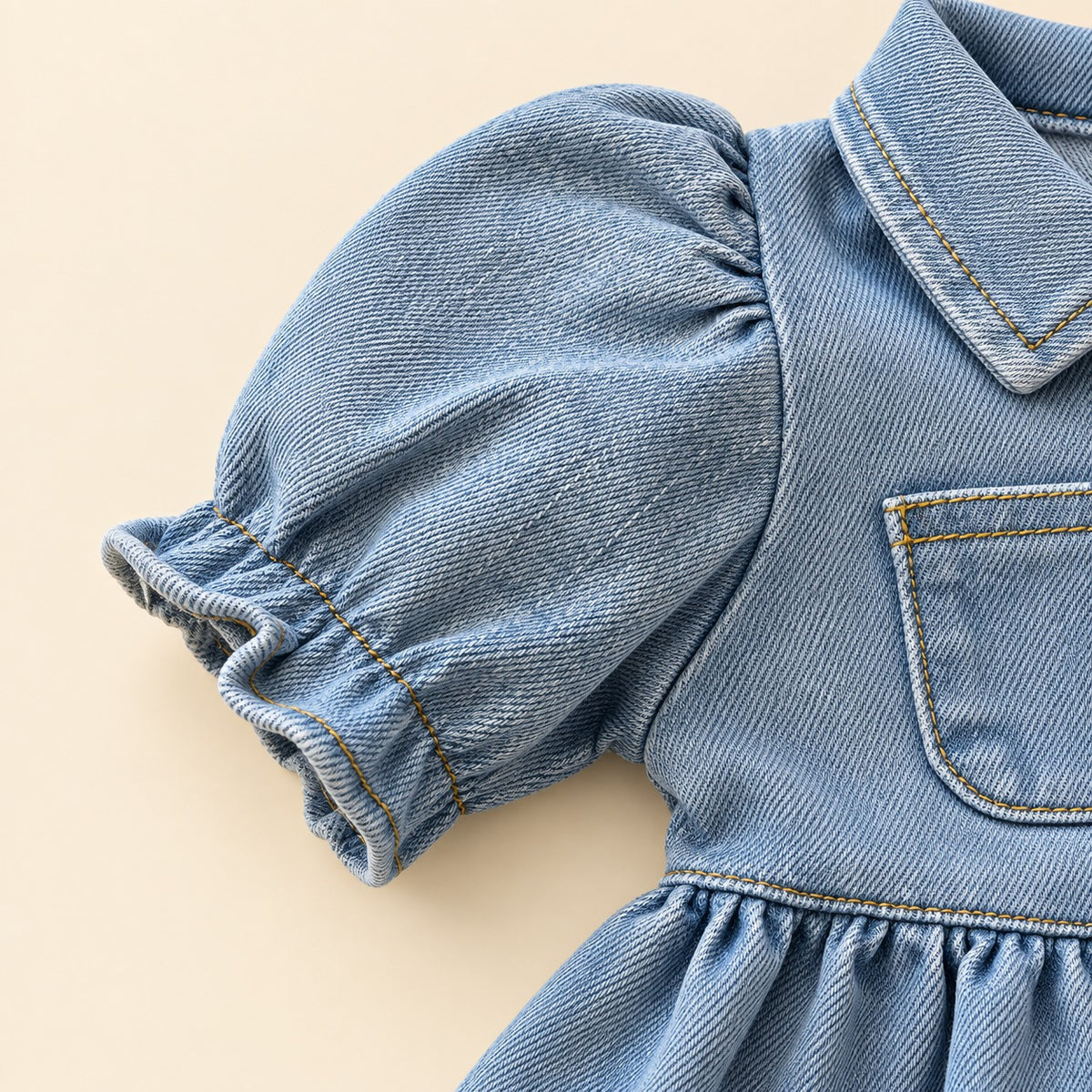 Vista posterior de bebé usando vestido denim azul claro con falda amplia