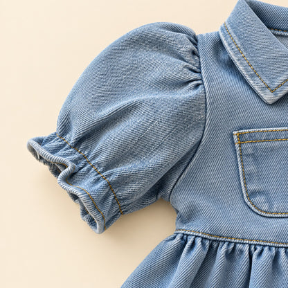 Vista posterior de bebé usando vestido denim azul claro con falda amplia