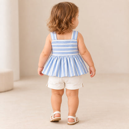 Niña usando conjunto azul cielo con blusa de rayas, moño blanco y short