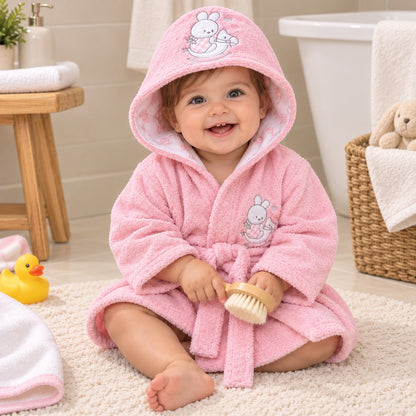 Bebé usando bata de baño rosada con capucha de conejita después del baño