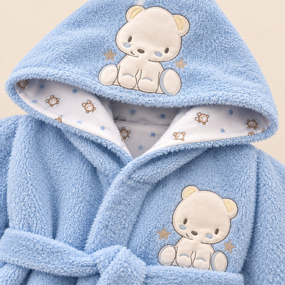 Bebé usando bata azul claro con capucha, mangas largas y cinturón