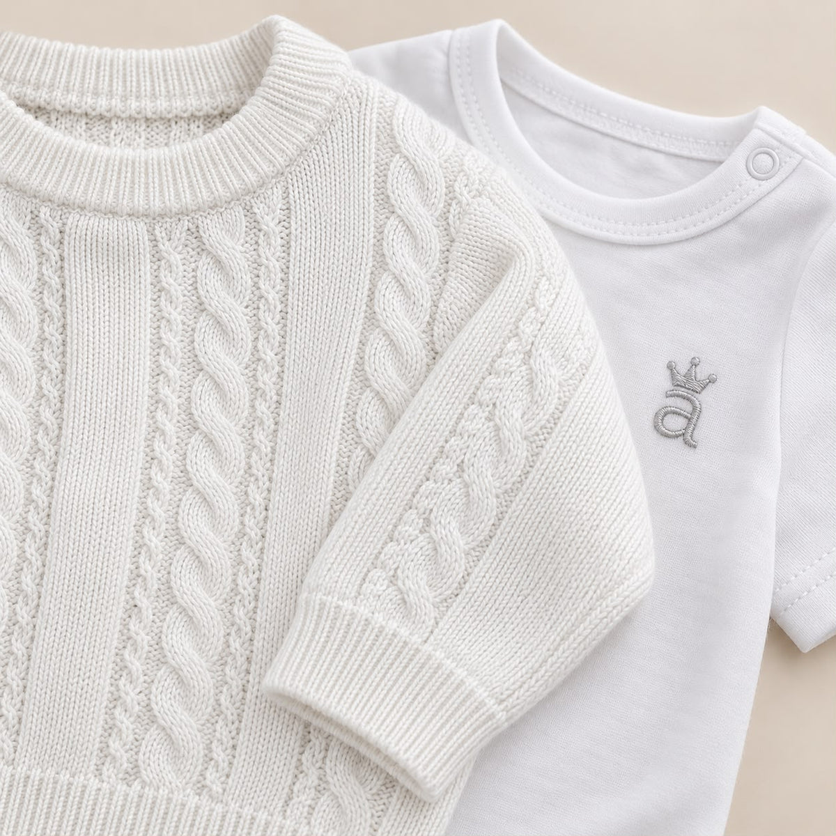 Bebé usando conjunto tejido blanco de cuatro piezas con suéter, pantalón con pie, gorro y body