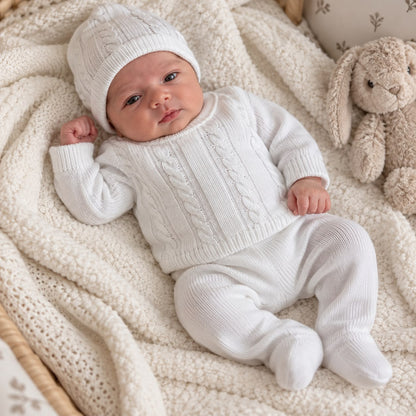 Conjunto blanco para bebé con suéter tejido, pantalón con pie, body y gorro