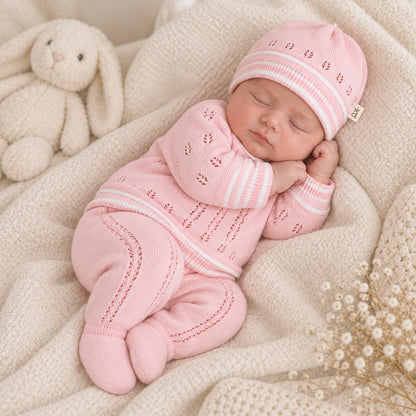 Cuatro piezas del conjunto tejido rosado para bebé extendidas: suéter, pantalón, body y gorro