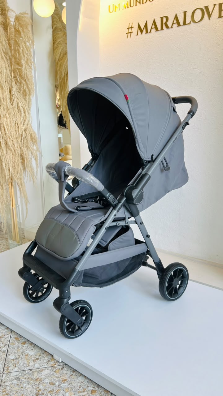 Coche compacto plegable gris para bebé con capota, barra frontal y canasta inferior
