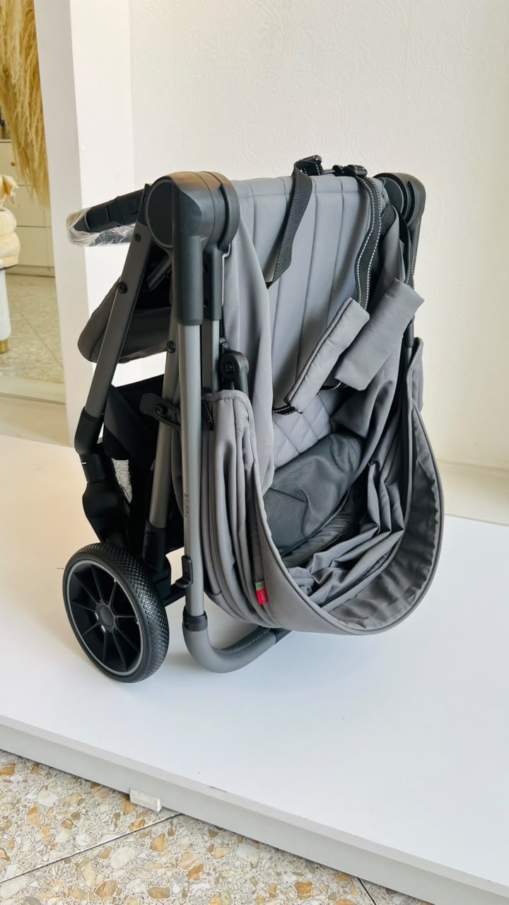 Detalle de ruedas y canasta inferior de coche gris para bebé