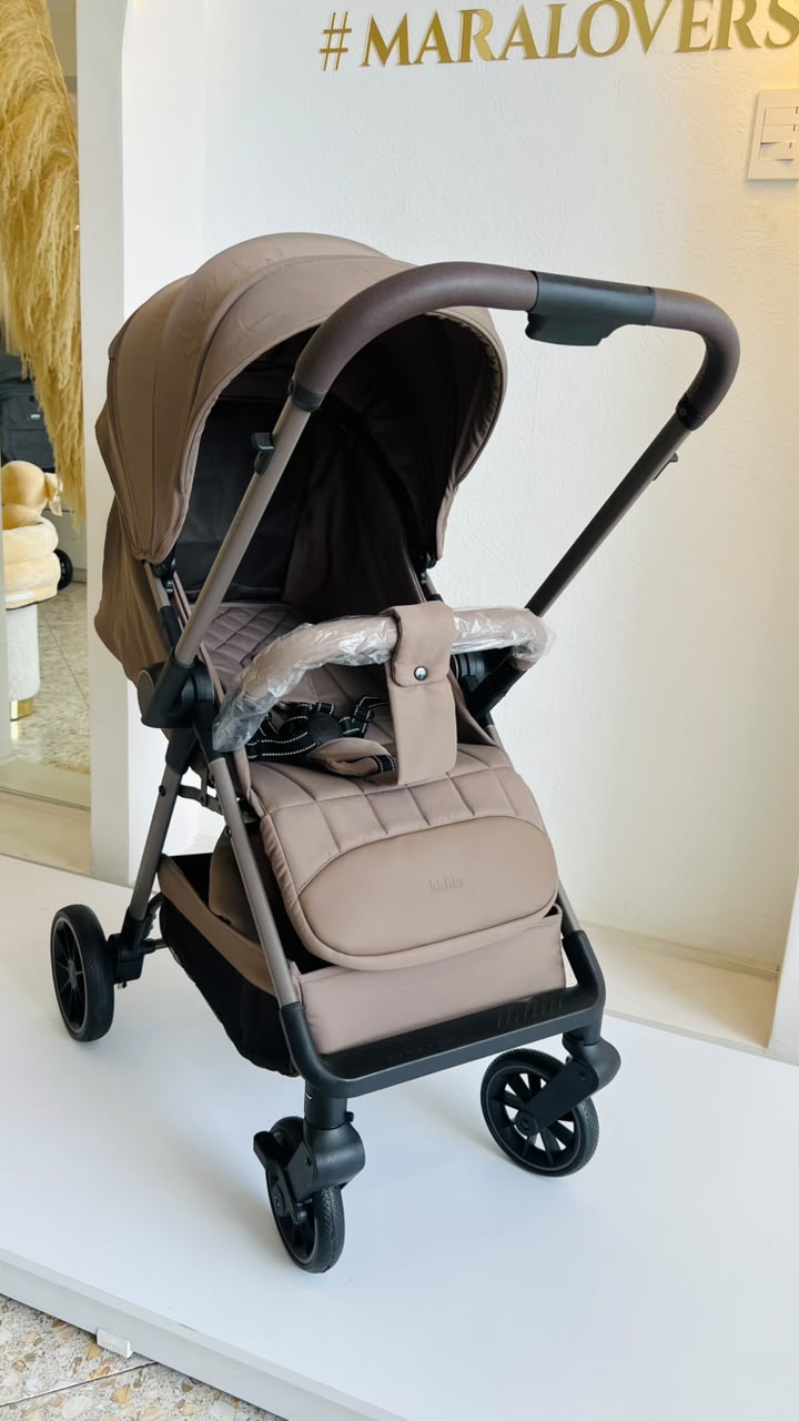 Vista lateral de coche Kidilo Sofi beige para bebé con capota y canasta inferior