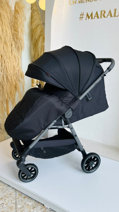 Vista lateral de coche Kidilo Sofi negro para bebé con capota y canasta inferior