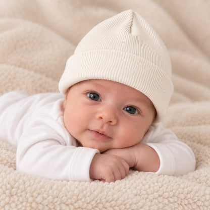 Bebé usando gorro tejido acanalado blanco en una manta