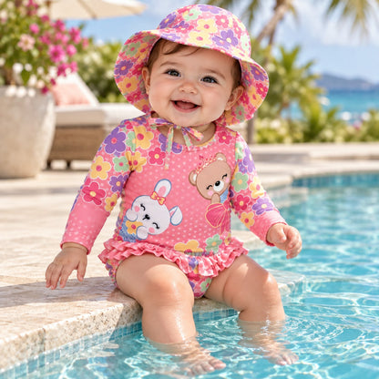 Bebé niña jugando en piscina inflable con vestido de baño rosado de flores y gorro