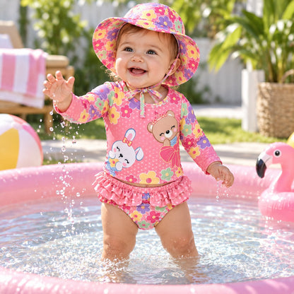 Niña en parque de agua con vestido de baño rosado de flores y gorro a juego