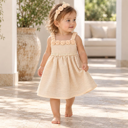 Niña caminando con vestido beige lino con rosas en el escote y diadema
