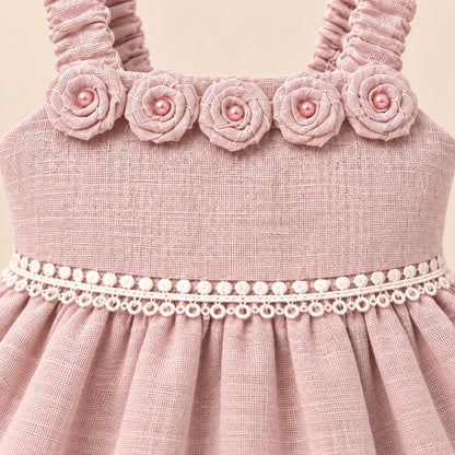 Niña de pie con vestido rosa palo de ocasión y diadema a juego