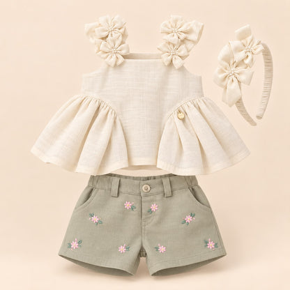 Vista posterior del conjunto: blusa beige con volantes, short verde salvia con bolsillos bordados y diadema