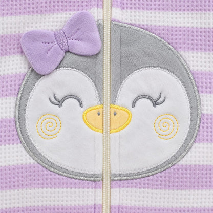 Bebé usando pijama enterizo lila y blanco con pingüino bordado