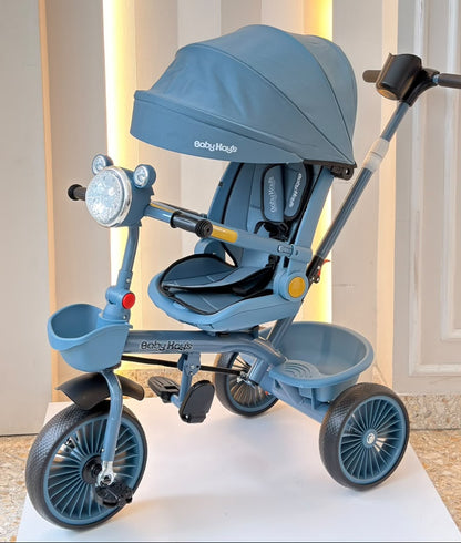 Triciclo infantil azul con capota, asiento acolchado y manija de empuje
