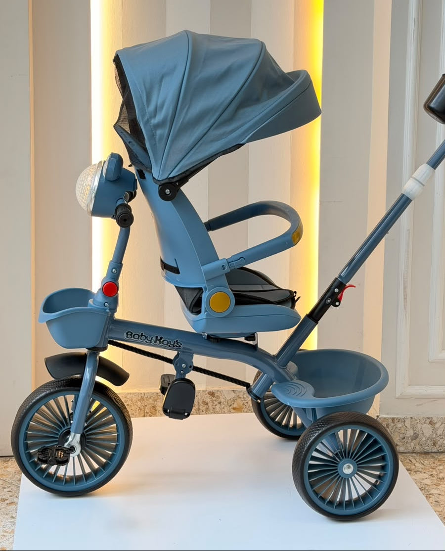 Triciclo infantil azul con capota amplia, pedales y ruedas anchas