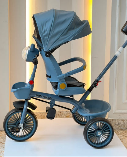 Triciclo infantil azul con capota amplia, pedales y ruedas anchas