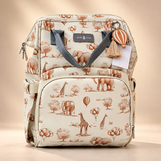 Mochila pañalera Safari Baby Luna en cuero vegano beige con estampado de elefantes y jirafas