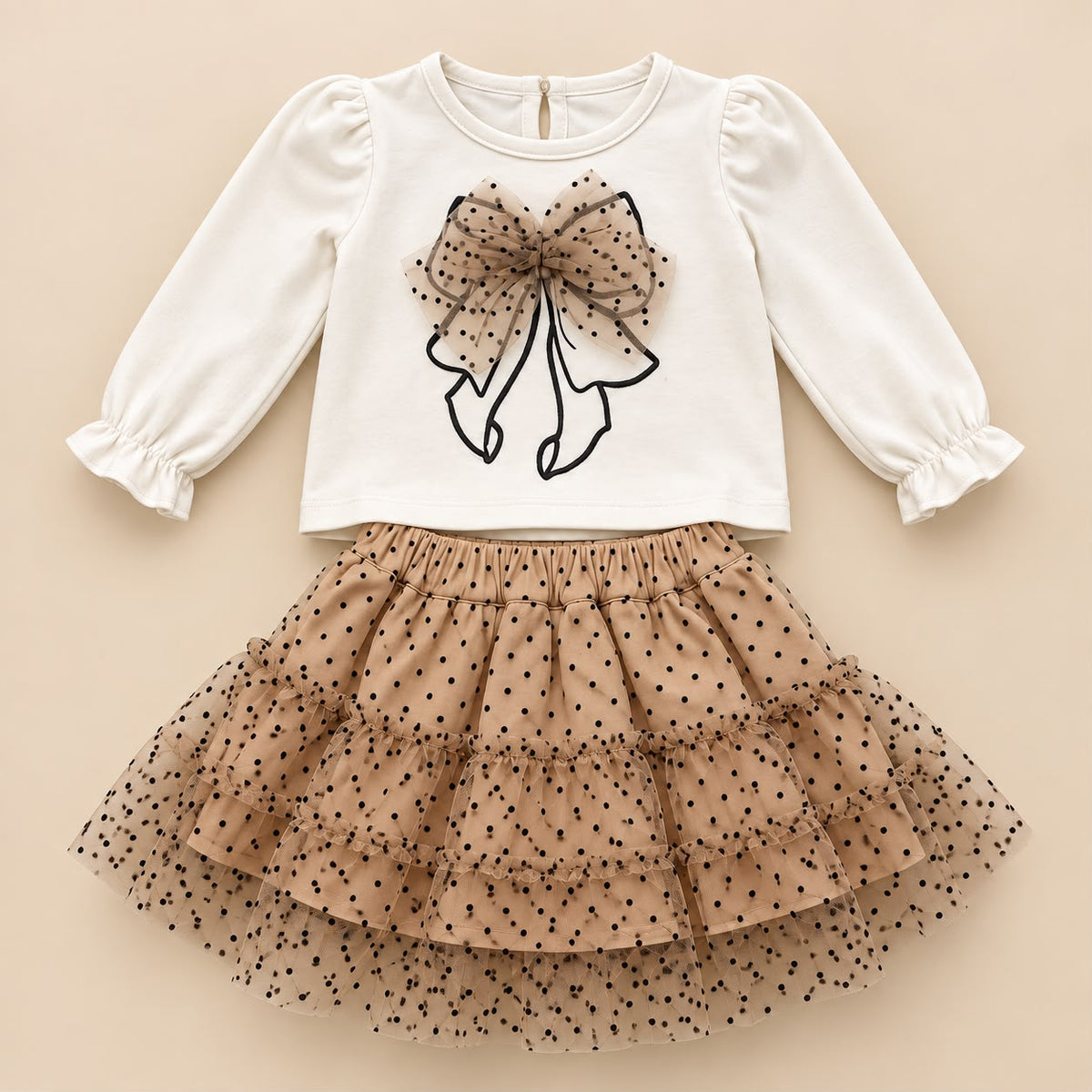 Vista posterior del conjunto para niña con blusa marfil y falda beige de tul