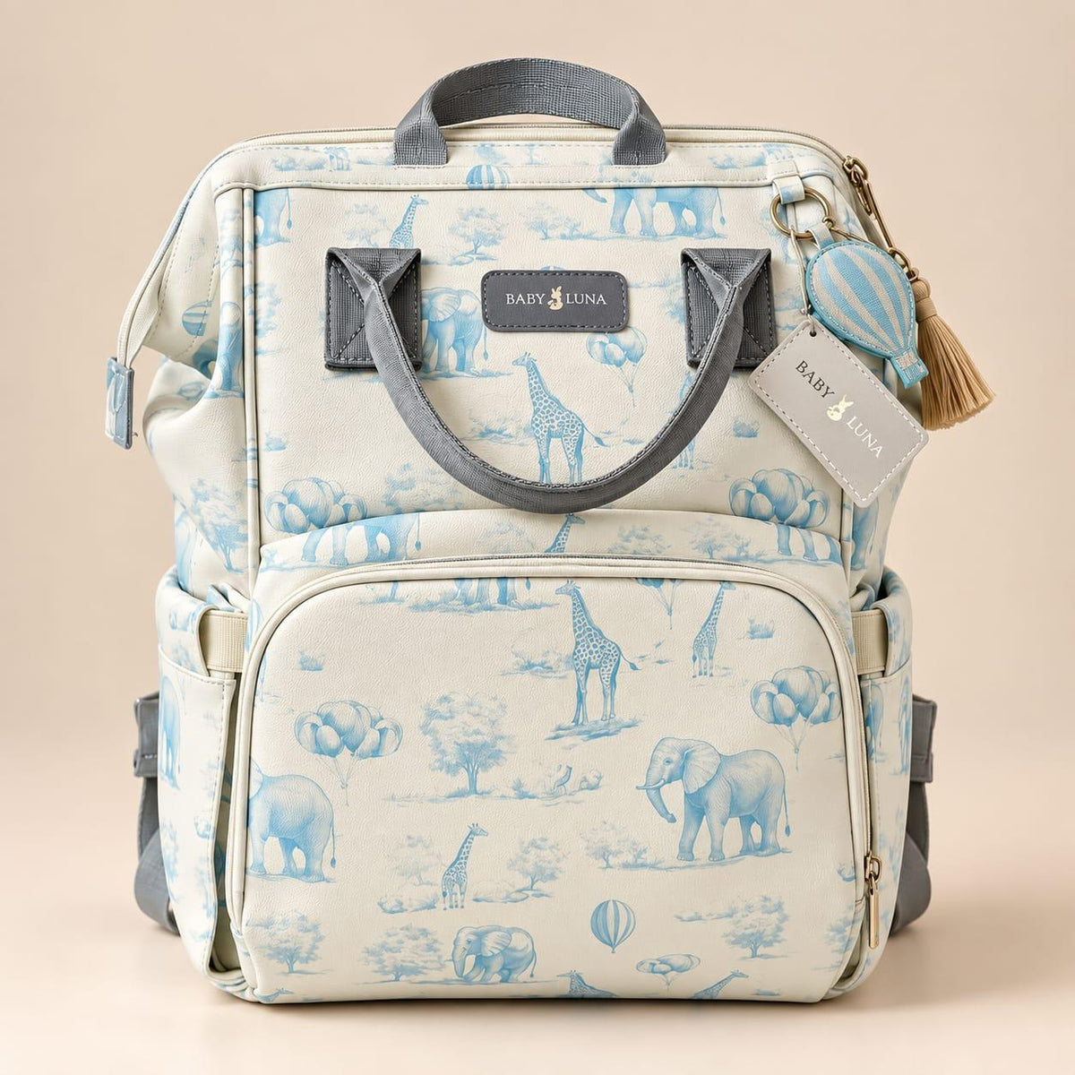 Vista frontal de la mochila pañalera Safari azul Baby Luna con estampado de elefantes y jirafas