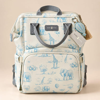 Vista frontal de la mochila pañalera Safari azul Baby Luna con estampado de elefantes y jirafas