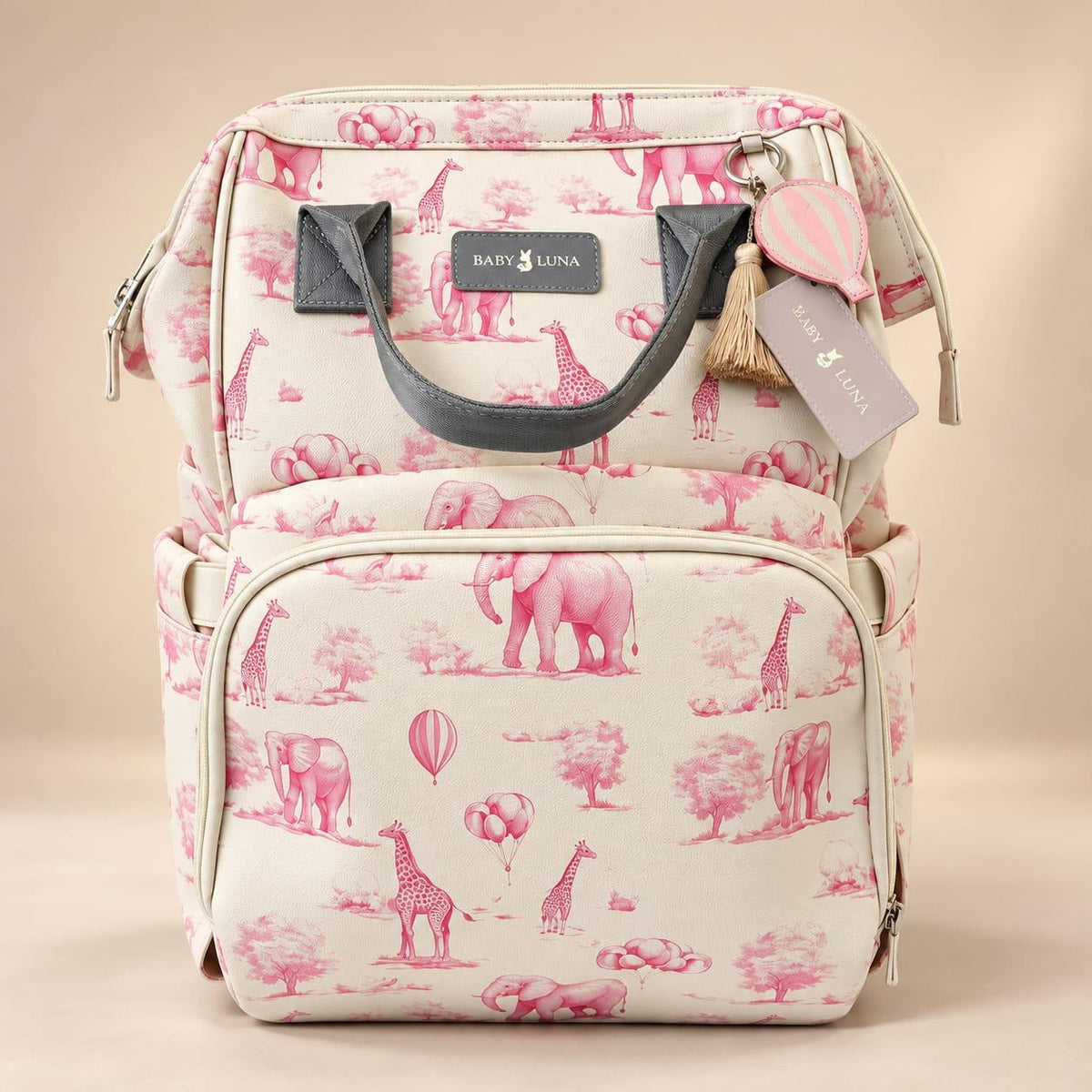Vista frontal de la mochila pañalera Safari rosa Baby Luna con estampado de elefantes y jirafas