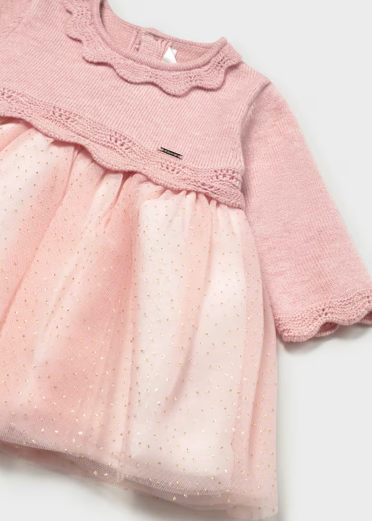 Detalle de cuello calado, cuerpo tejido rosa y falda de tul crema del vestido Mayoral para recién nacida