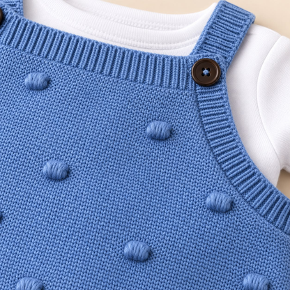 Detalle de enterizo tejido azul para bebé con botones y pequeños relieves