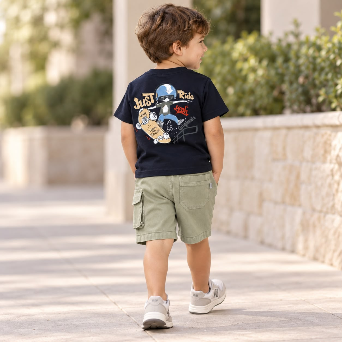 Niño usando conjunto azul marino y verde caqui con camiseta estampada y short cargo