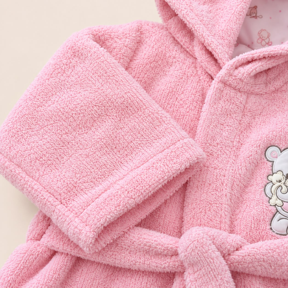 Detalle de la textura de bata de baño rosada para bebé y cinturón para anudar