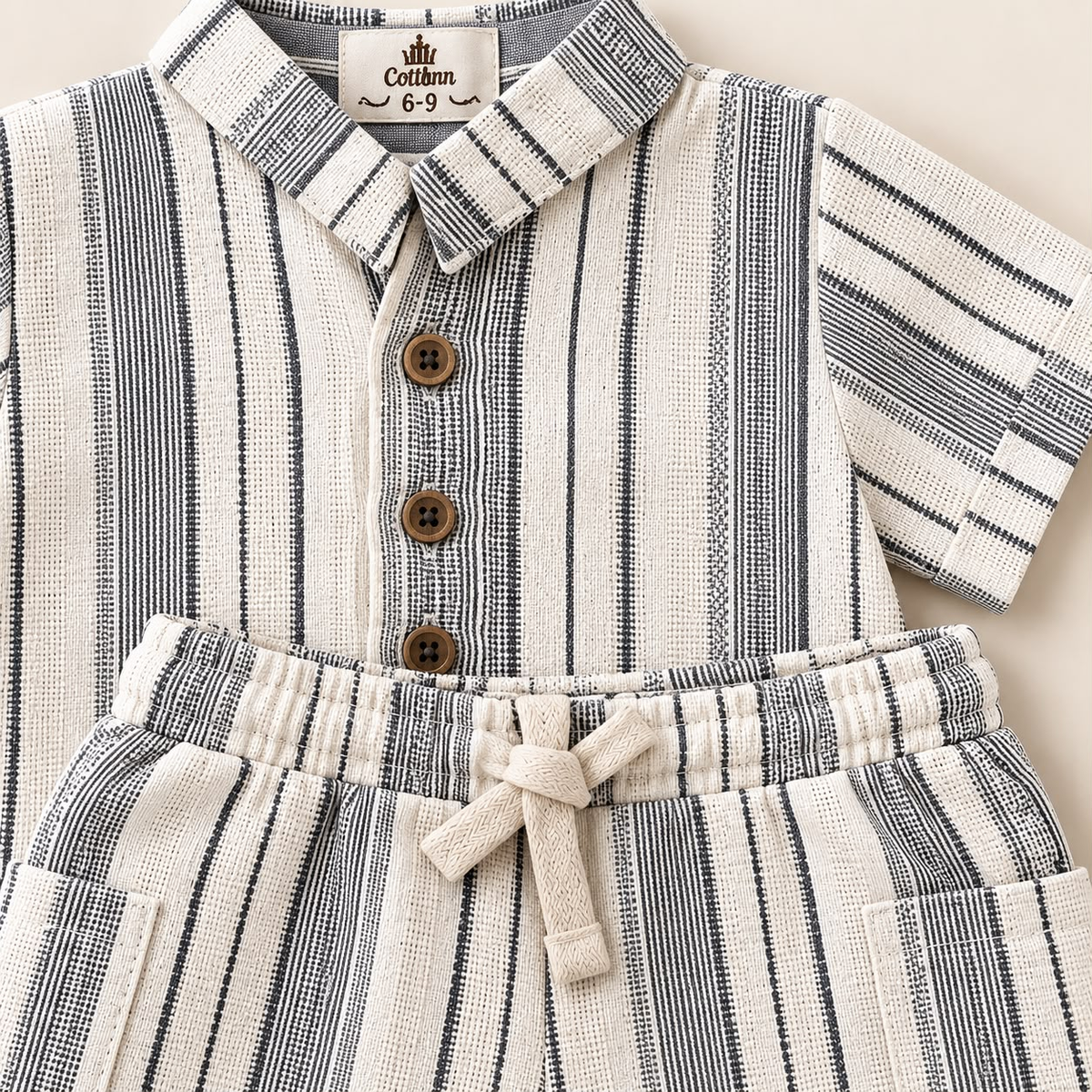 Detalle de camisa y short para bebé con rayas negras, botones y cordón