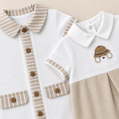 Detalle de prendas para bebé blancas con acabados beige a rayas y botones cafés