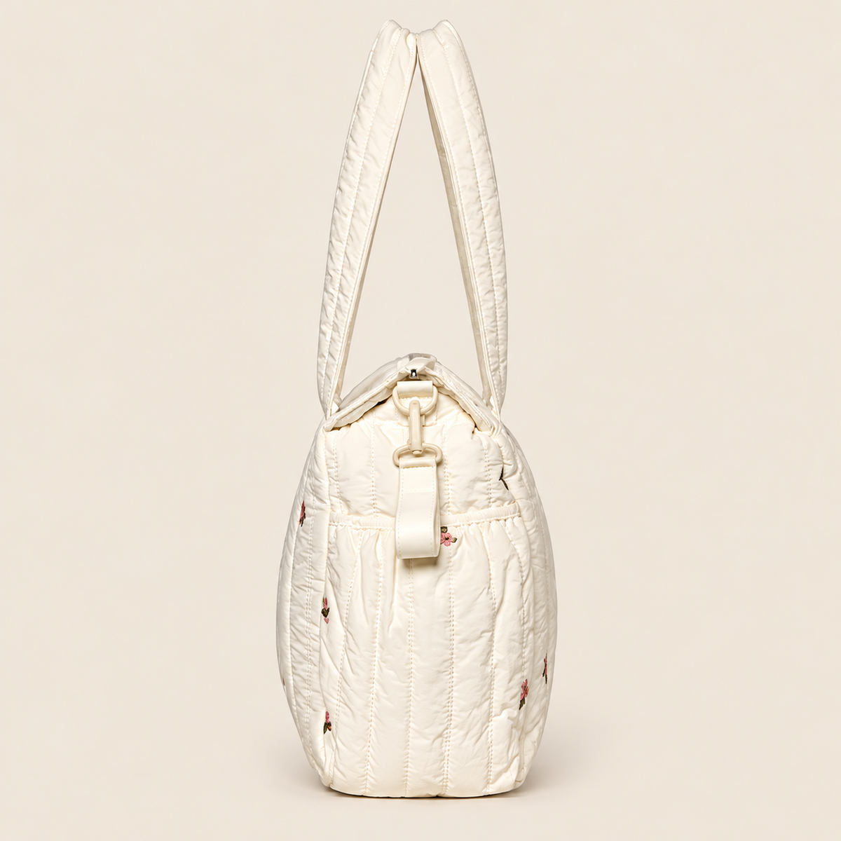 Pañalera para bebé crema acolchada con diseño floral, vista lateral