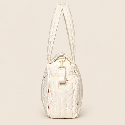 Pañalera para bebé crema acolchada con diseño floral, vista lateral