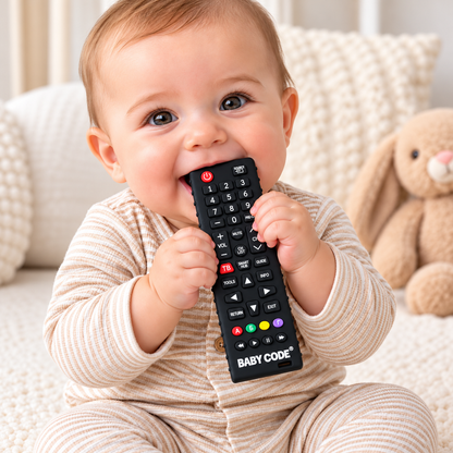 Bebé sosteniendo un rascador de encías Baby Code negro con forma de control remoto
