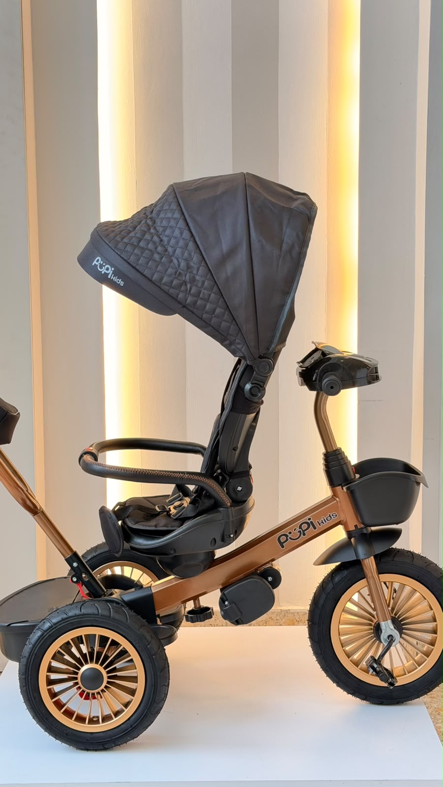 Triciclo Pupi Kids cobrizo y negro con capota, vista lateral