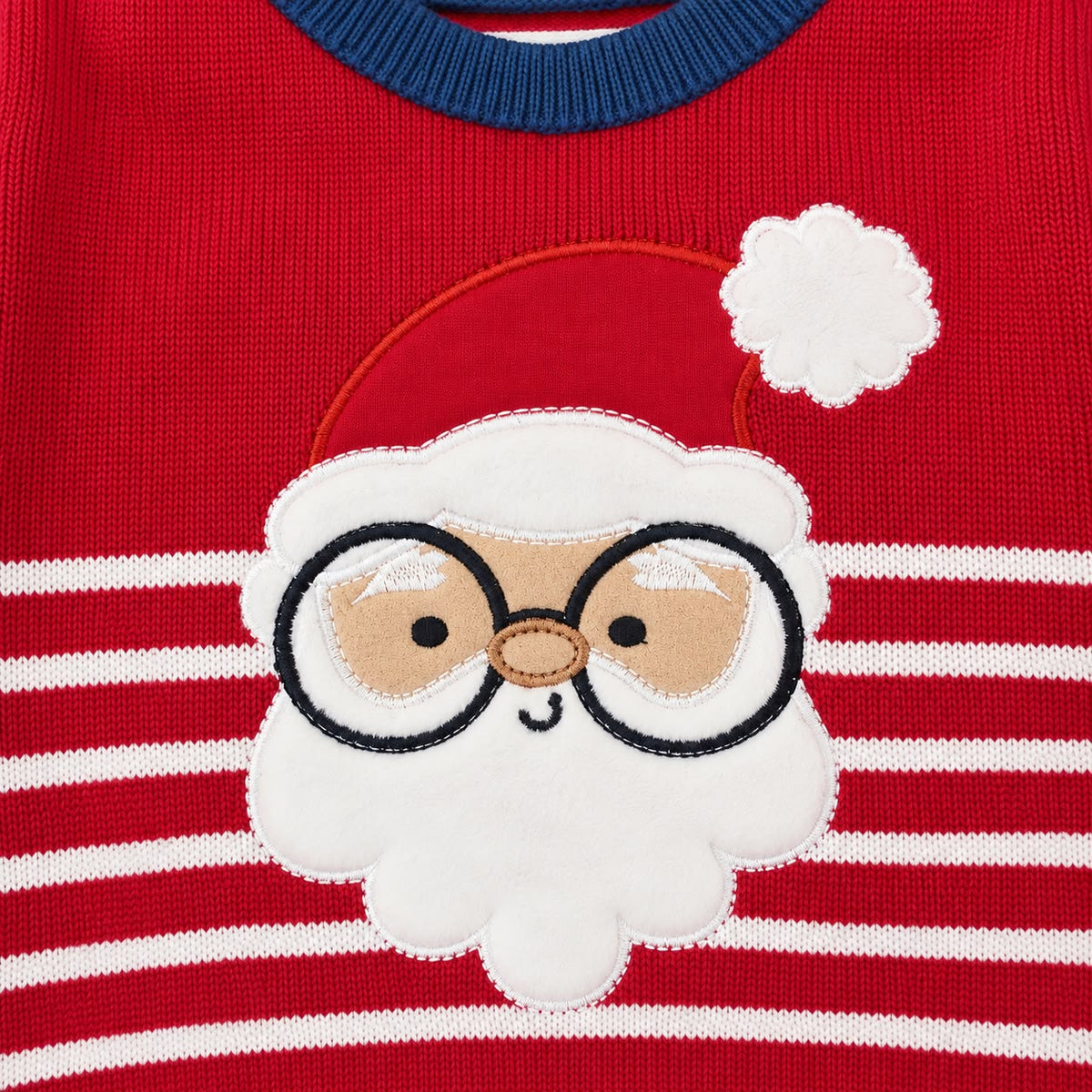 Detalle del aplique de Papá Noel con gafas en suéter navideño rojo